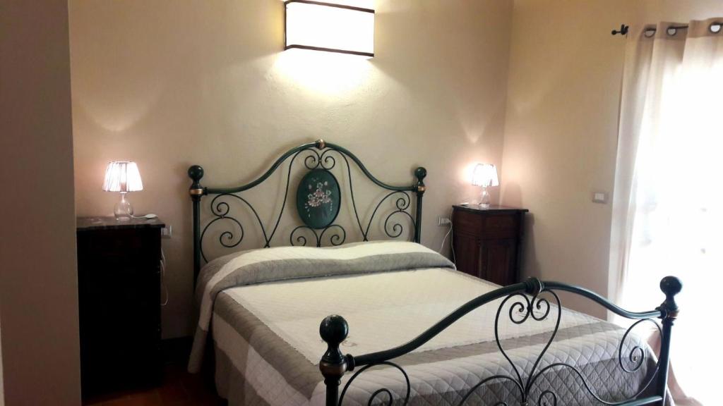 a bedroom with a bed and two lamps and a window at La Tenuta di Castelvecchio in San Gimignano