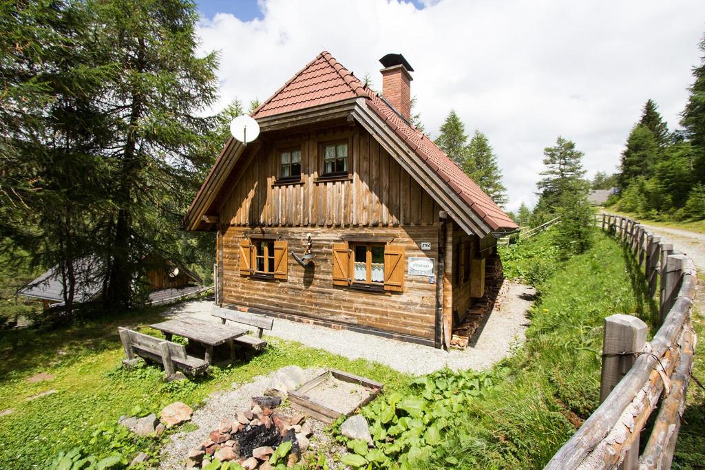 una piccola casa in legno con una panchina accanto a una recinzione di Almhaus Völkl a Ramingstein