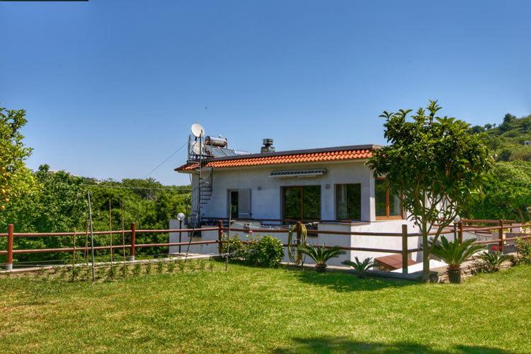 een wit huis met een hek en een tuin bij Le Castagne Apartments Ischia in Ischia