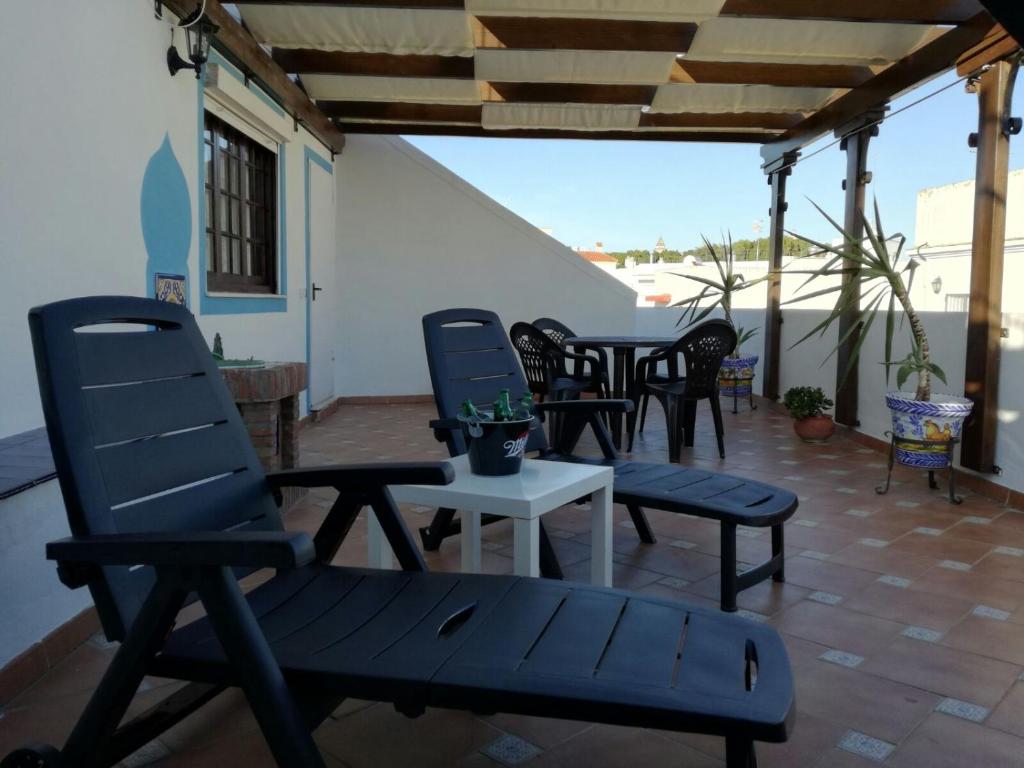 eine Terrasse mit 4 Stühlen und einem Tisch in der Unterkunft Atico SIROCO in Sanlúcar de Barrameda
