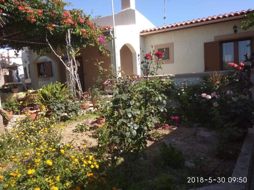 a garden in front of a house with flowers at Phaistos Country House in Mitrópolis