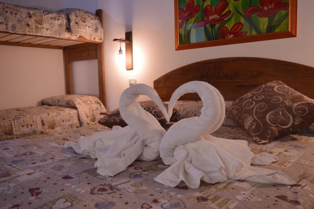 Dwa łabędzie tworzące serce na łóżku w obiekcie Vin e Turn w mieście Diamante