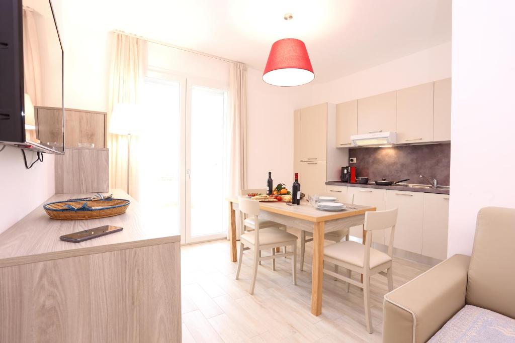 a kitchen and dining room with a table and chairs at Alma di Alghero Apartments in Alghero