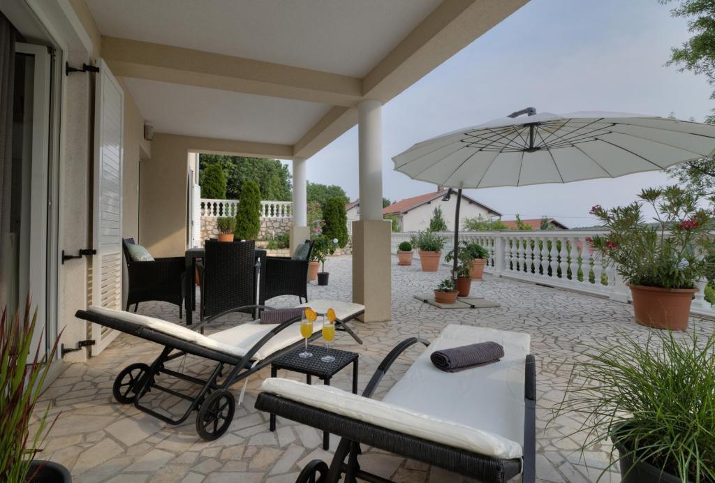 een patio met een tafel en een parasol bij Apartment Barbara in Senj