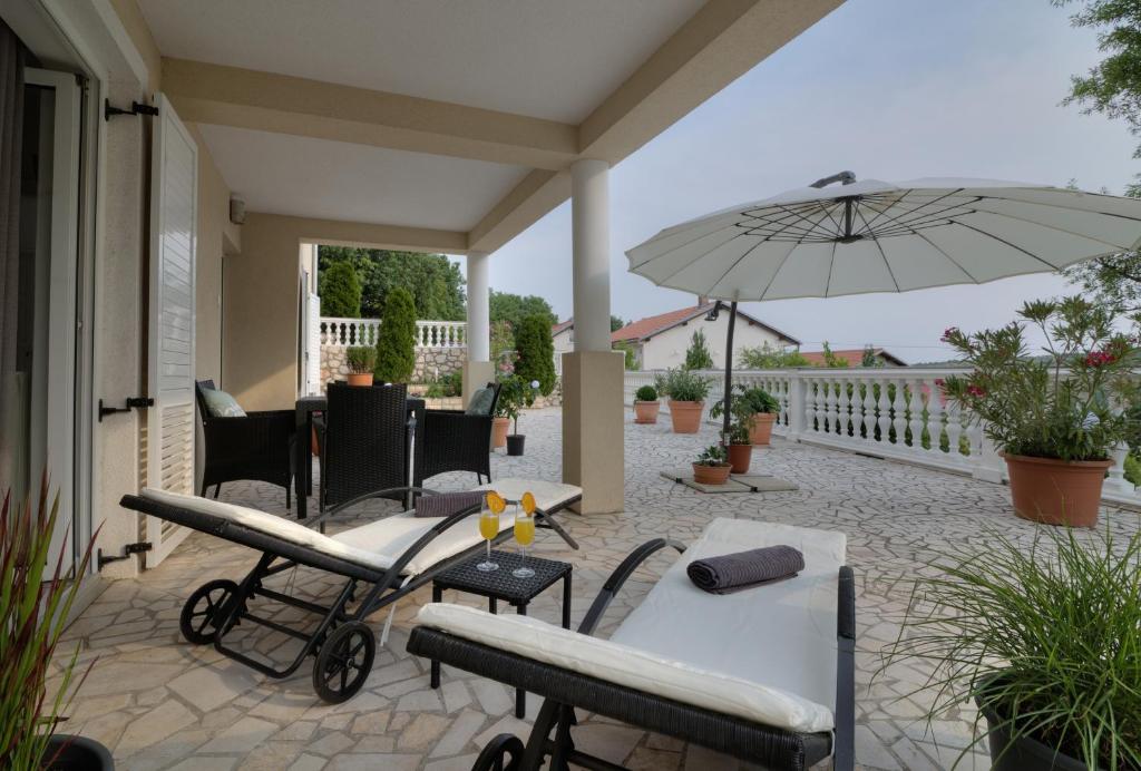 a patio with a table and an umbrella at Apartment Barbara in Senj