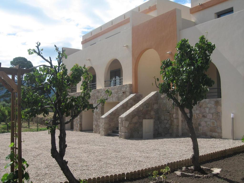 um edifício com árvores em frente em Residences Santa Vittoria em Algajola