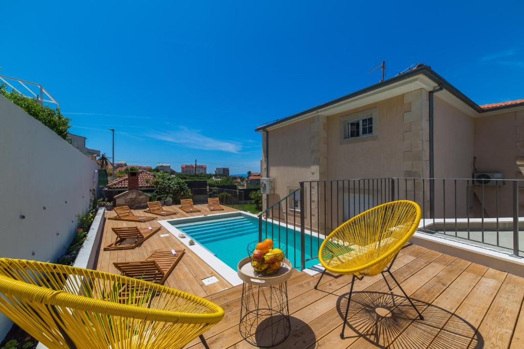 een balkon met gele stoelen en een zwembad bij Villa Artea in Podstrana