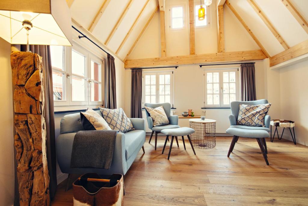 ein Wohnzimmer mit Sofas, Stühlen und Fenstern in der Unterkunft Kronser Ferienwohnungen in Bernkastel-Kues