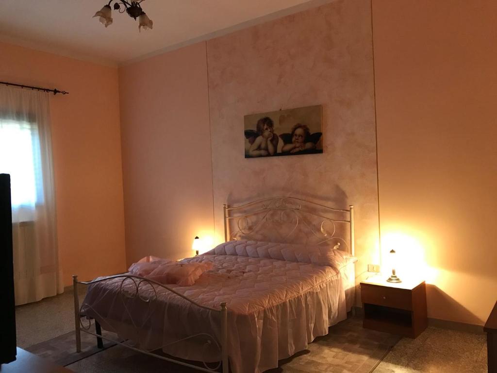 ルッファーノにあるCasa Vacanza da Giò con PISCINA PRIVATAのベッドルーム1室(ベッド1台付)が備わります。壁に2枚の写真が飾られています。