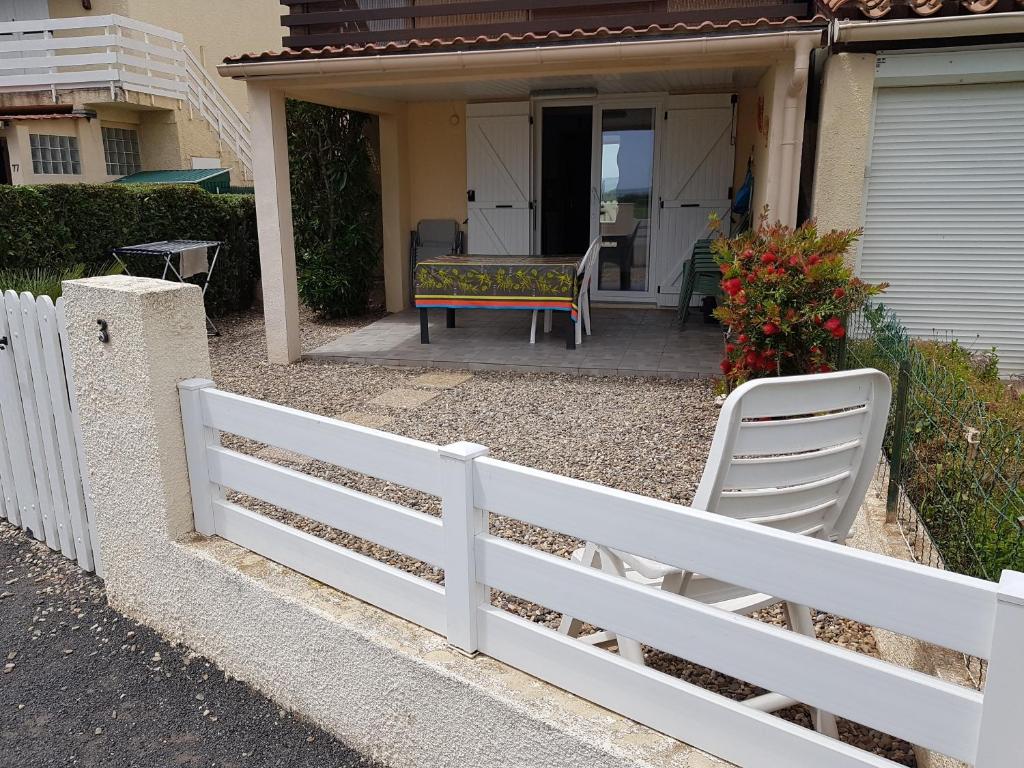 une clôture blanche devant une maison dans l'établissement Comme à la maison, à Marseillan