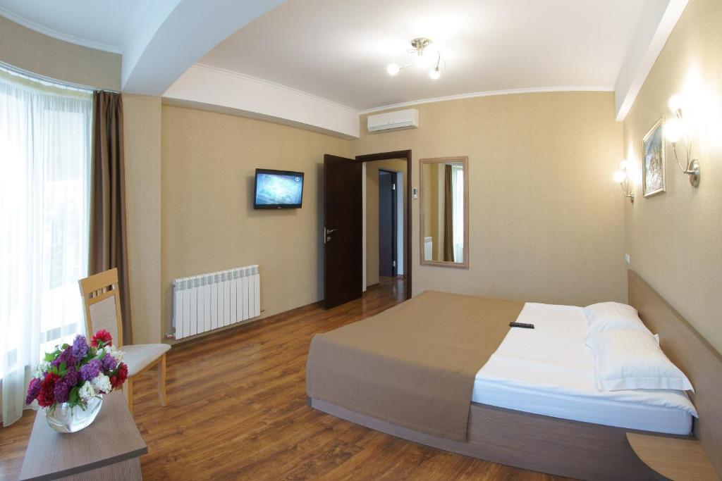 una habitación de hotel con una cama grande en una habitación en Darya Hotel, en Alushta
