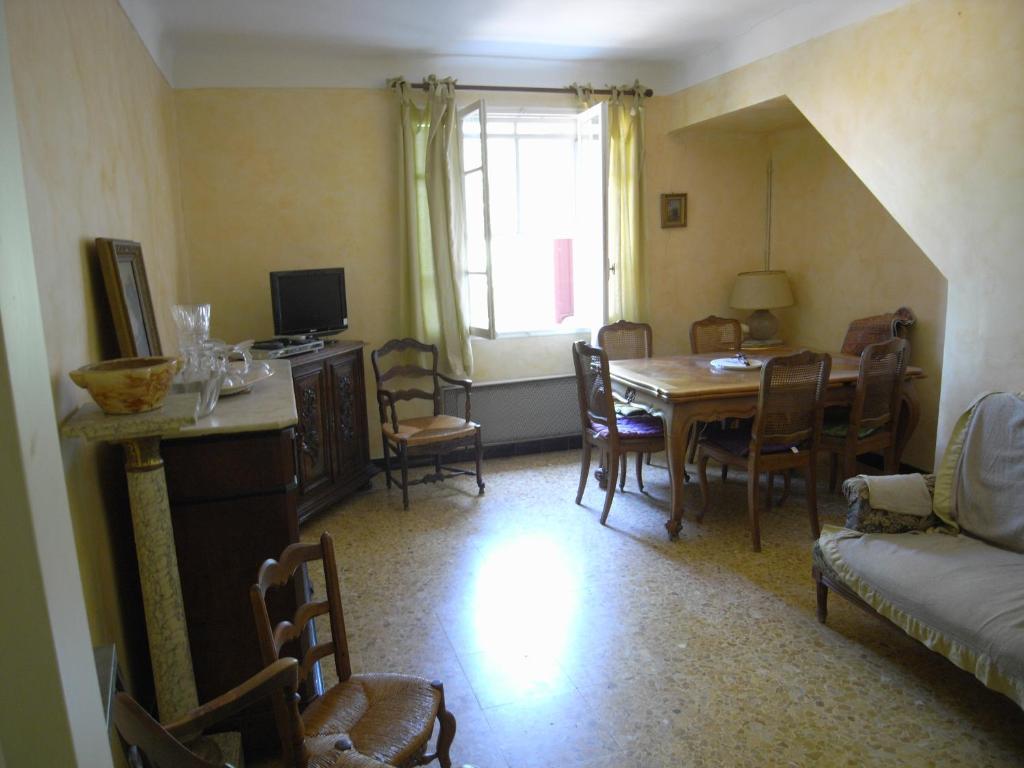 een woonkamer met een eettafel en stoelen bij aile d'un ancien mas in La Roque-dʼAnthéron