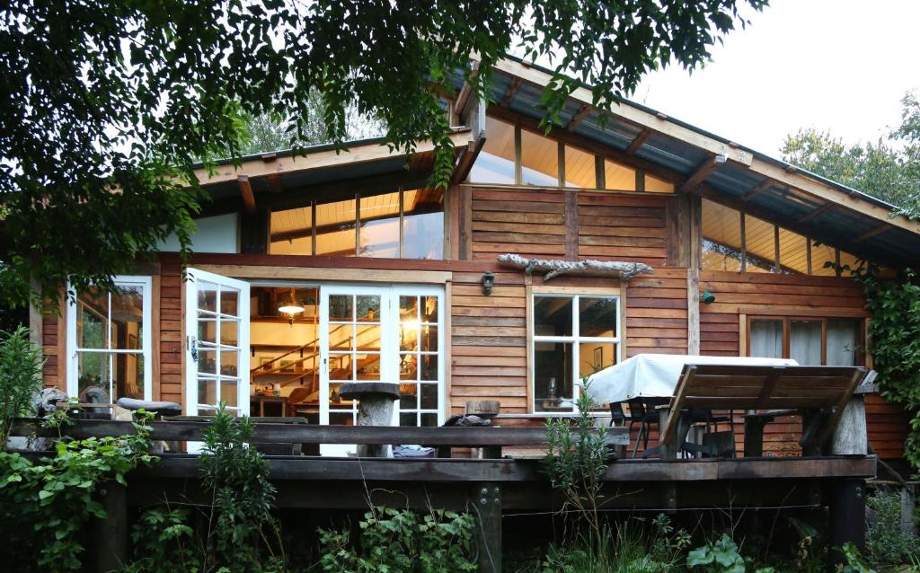 una cabaña de madera con una terraza frente a ella en Boutique Vintage Forest Cabin, en Stormsrivier