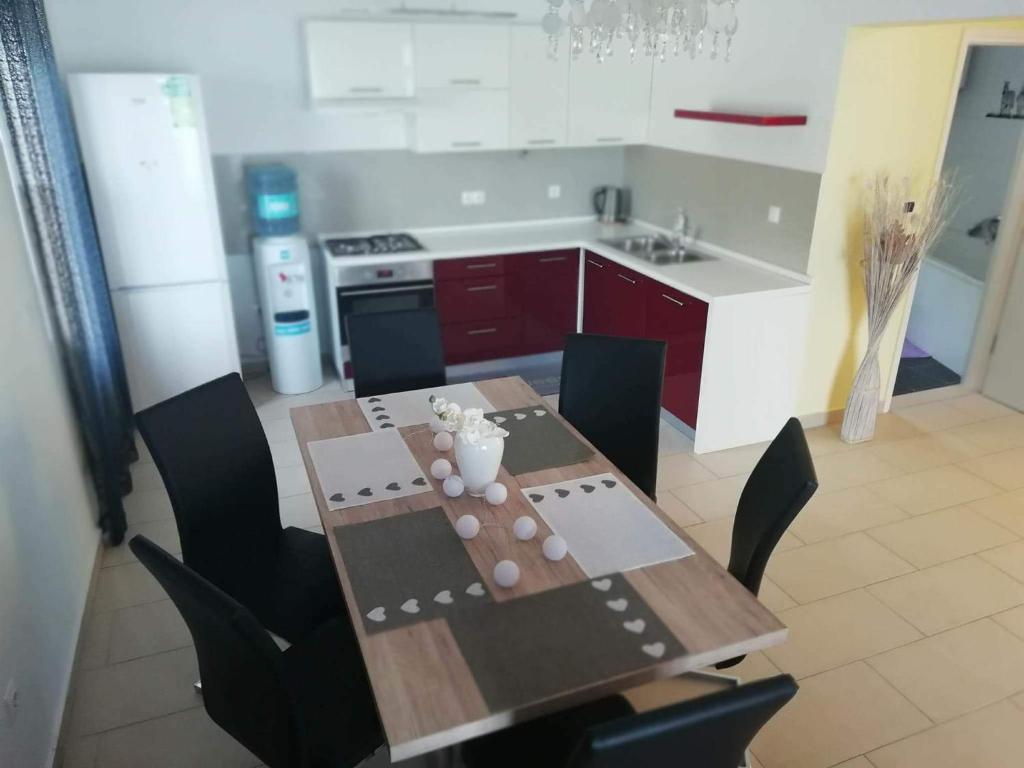 eine Küche mit einem Holztisch mit Stühlen und einem Waschbecken in der Unterkunft Apartman BubaMara in Sveti Juraj