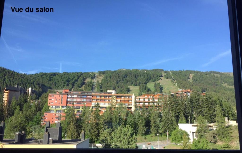 ein großes Gebäude auf einem Hügel mit einem Berg in der Unterkunft Appartement chalet PRA LOUP 1600 La sapinière in Pra-Loup