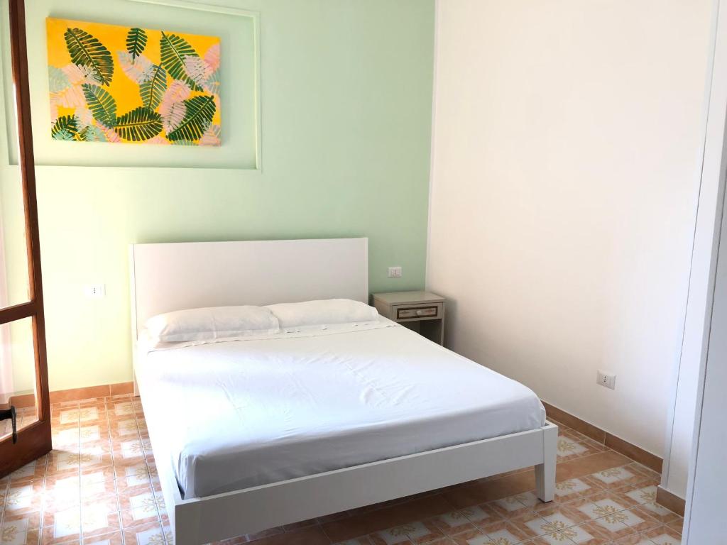 ガリポリにあるSpiaggia Baia Verde Gallipolitravelの壁に絵が描かれた部屋の白いベッド1台