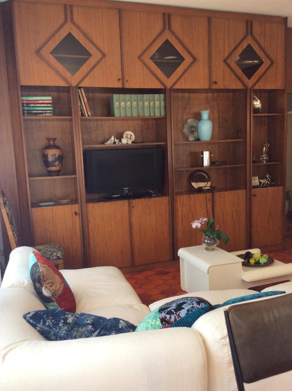 uma sala de estar com um sofá branco e uma televisão em Manu Vintage B&B em Cattolica