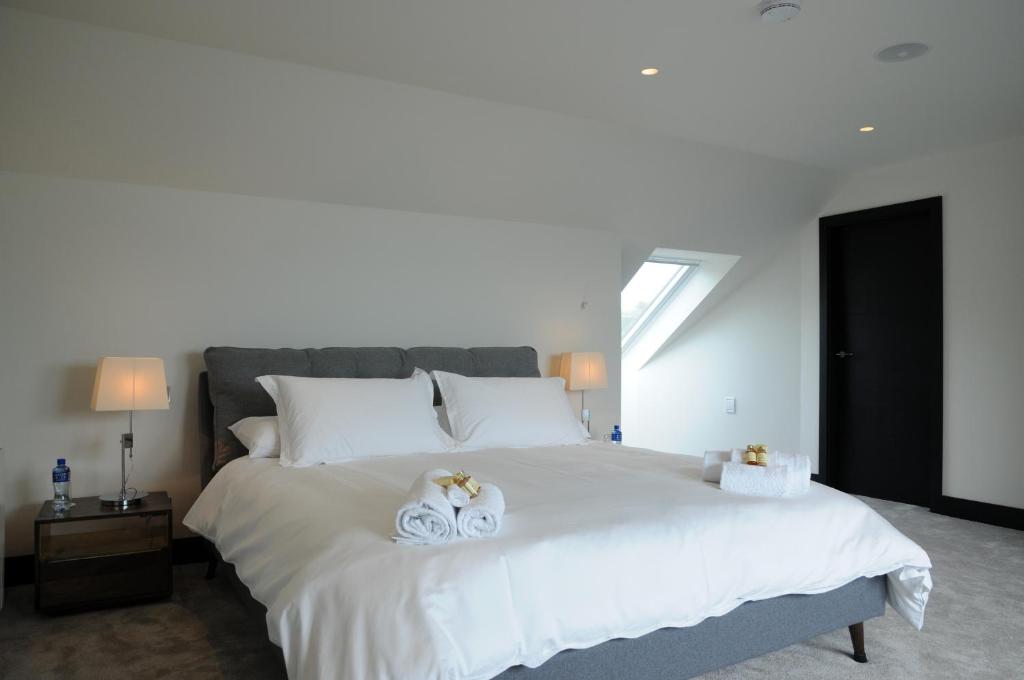 a bedroom with a large white bed with two towels at Seascapes in Inch