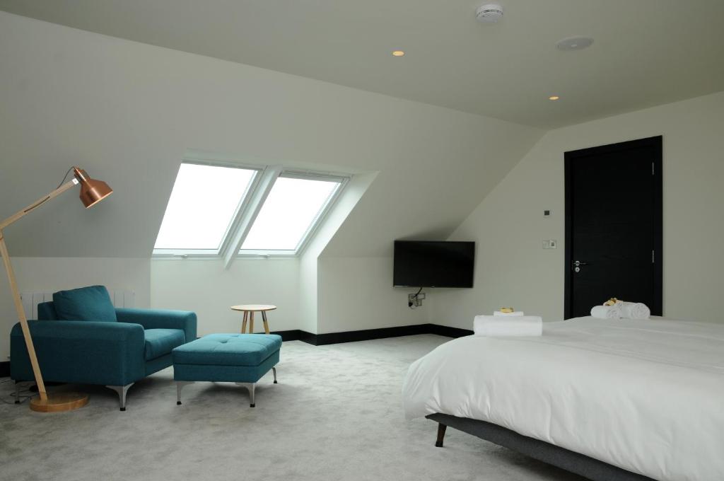 una camera con letto, sedia e TV di Seascapes a Inch