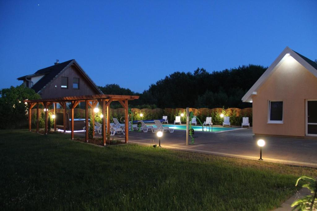 a house with lights in a yard at night at Verano in Osieki