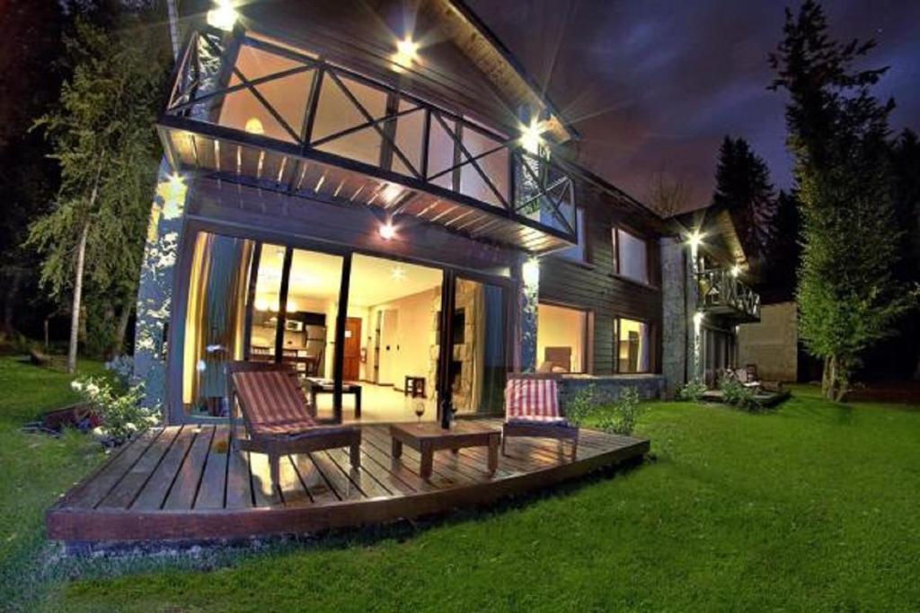 una casa con dos sillas y un banco en una terraza en Orillas del Gutierrez en San Carlos de Bariloche