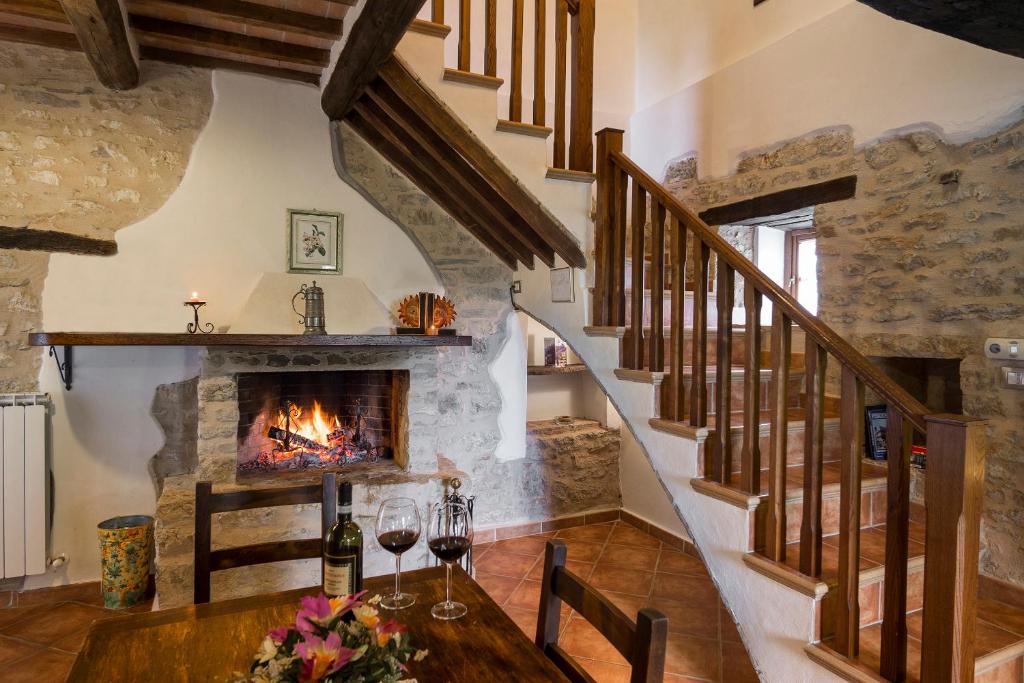 ウンベルティデにあるAgriturismo Monte Acutoの暖炉とワイングラス付きのテーブルが備わるダイニングルーム