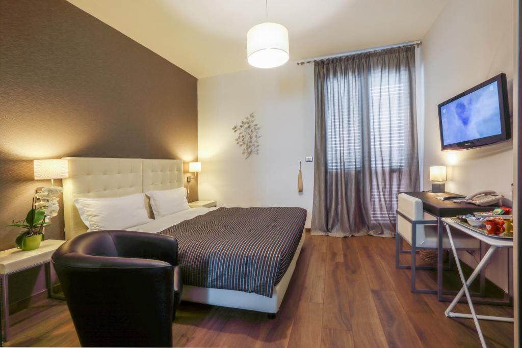 a bedroom with a bed and a desk and a television at B&B Night&Day in Reggio di Calabria