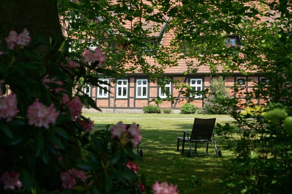 einem Stuhl im Gras vor einem Gebäude in der Unterkunft Beekenhof in Bommelsen