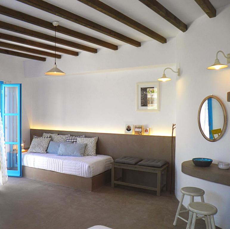 a bedroom with a bed and a mirror and a stool at Aegean Eye Apartments in Kástron