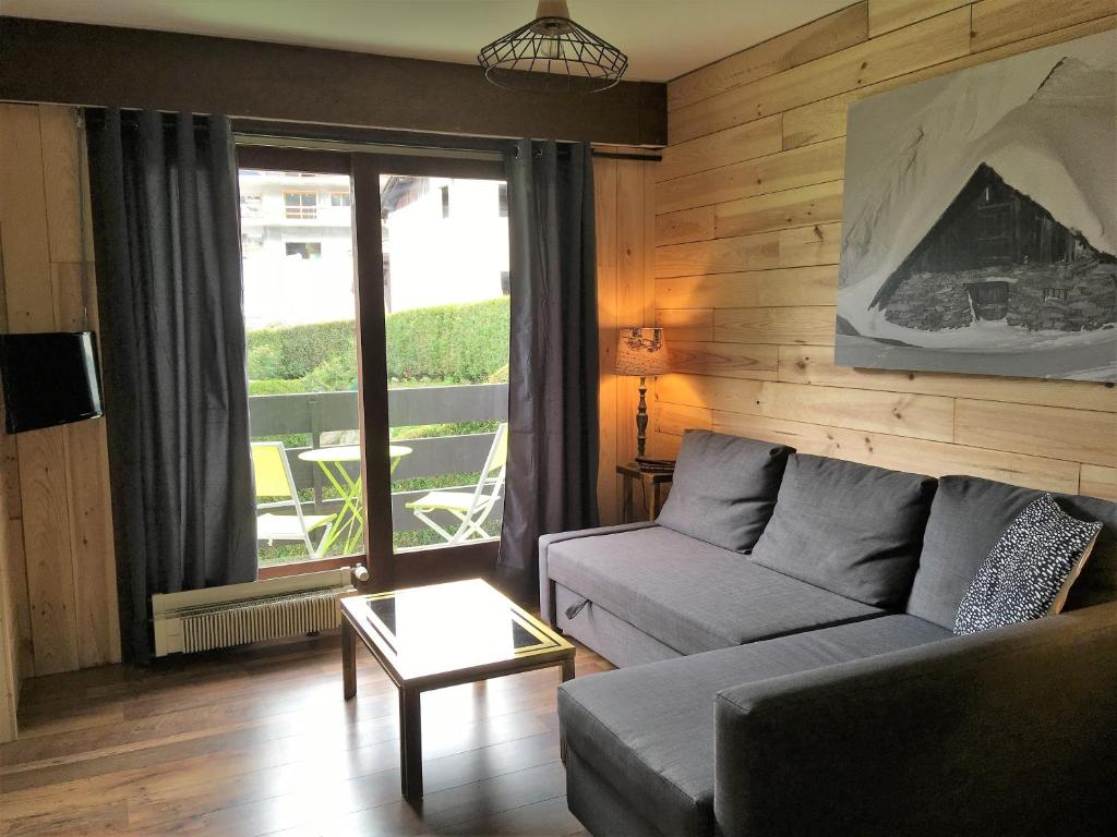 uma sala de estar com um sofá e uma mesa em Les Esserts em Les Houches