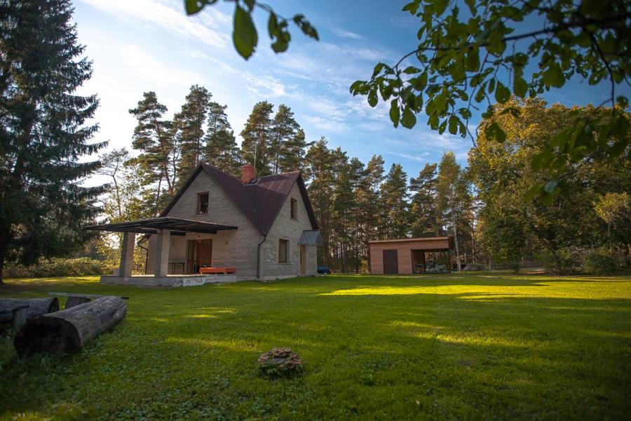 a house in the middle of a green yard at Brīvdienu māja Sauleskrasti in Mērsrags