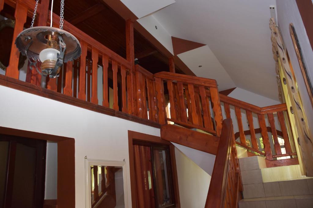 a wooden staircase in a house with a chandelier at Cabana Steaua Nordului 2 in Vînători