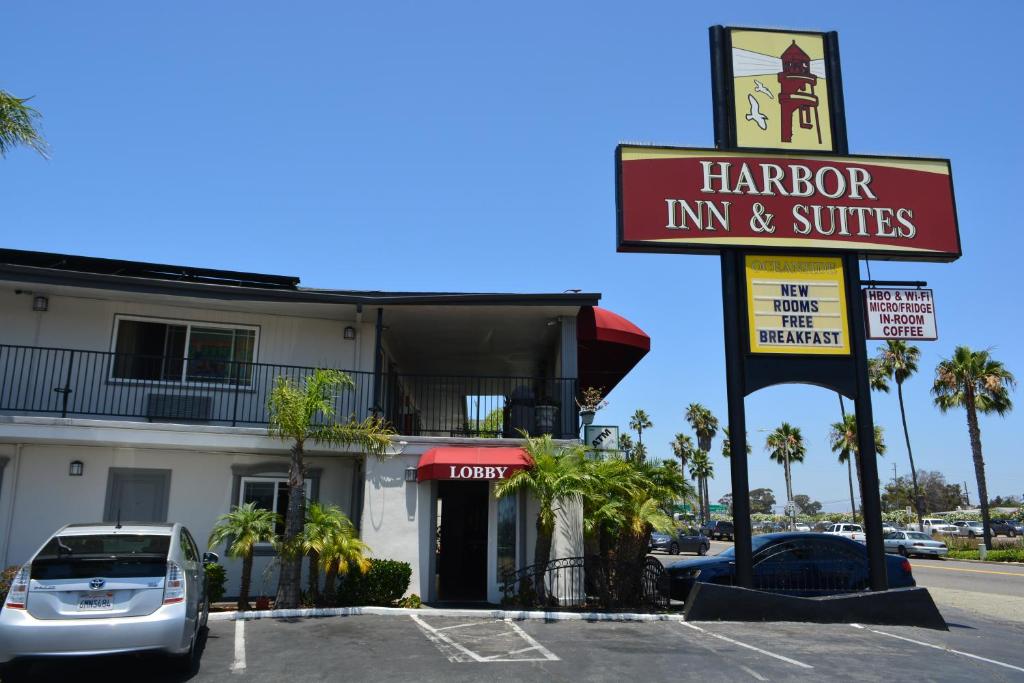 Una posada de arpones y suites firman frente a un edificio en Harbor Inn & Suites Oceanside, en Oceanside
