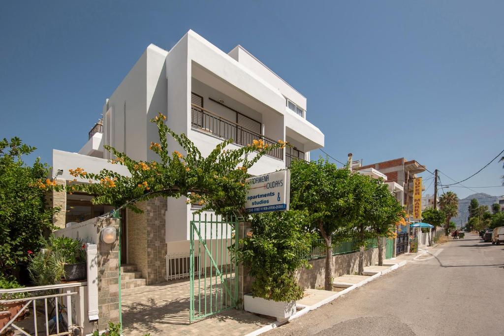 un bâtiment blanc sur le côté d'une rue dans l'établissement Kardamena Holiday Apartments, à Kardamaina