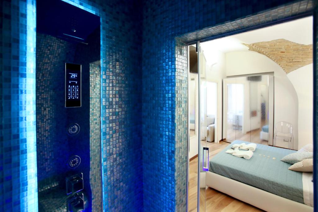 テルモリにあるStella Maris suite relaxの青いタイルの壁のベッドルーム、ベッド1台が備わります。