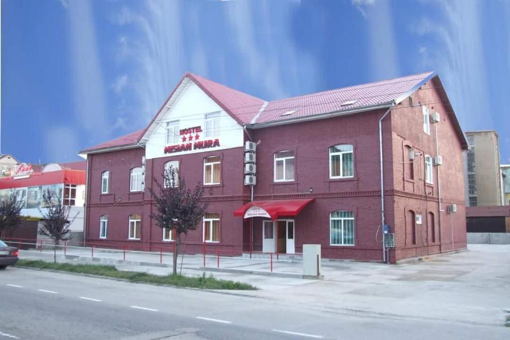 um grande edifício de tijolos vermelhos com um hotel em Mi Sian Mura em Lugoj