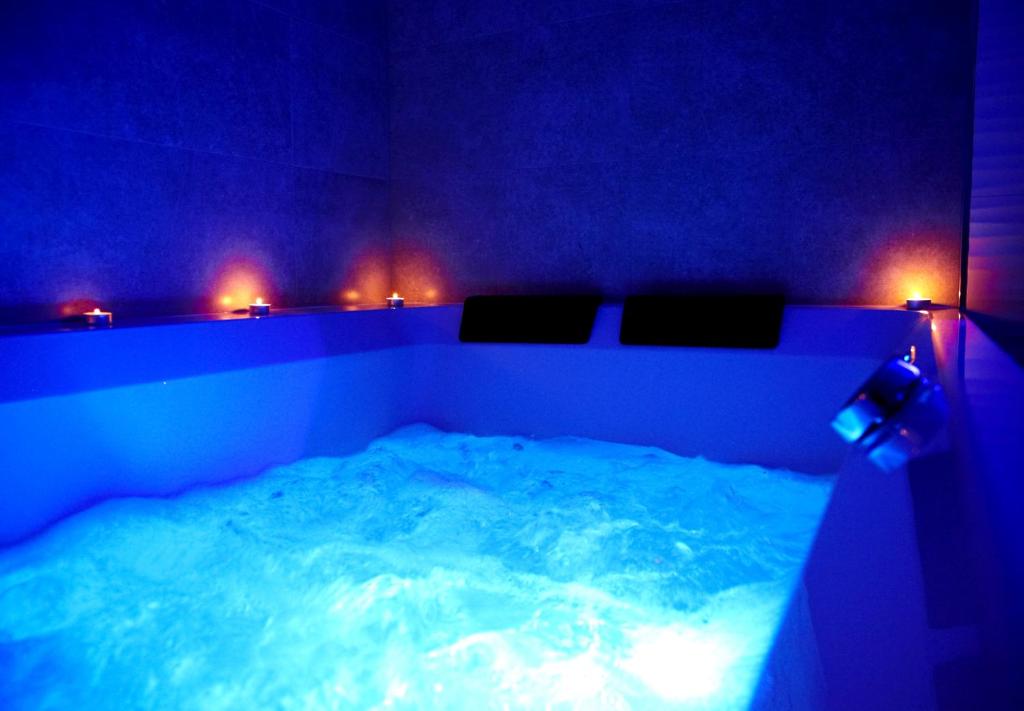 a blue room with a large tub with lights at Lemmas Apartament Anchoria in Mechelinki