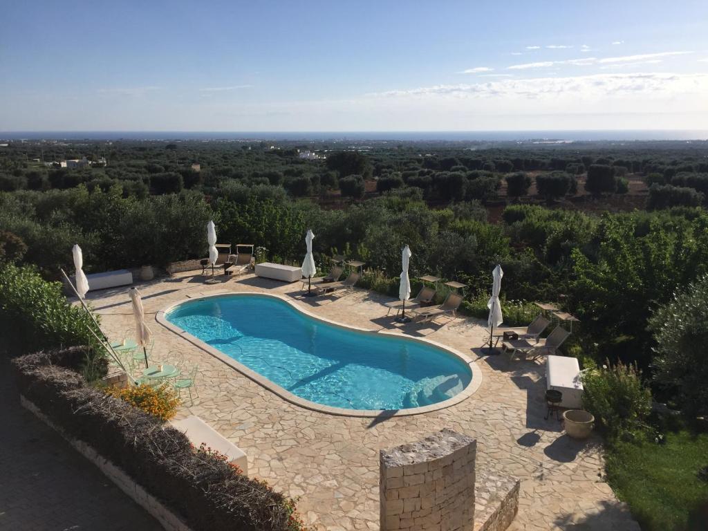 a swimming pool with chairs and umbrellas at B&B Antico Carrubo in Monopoli