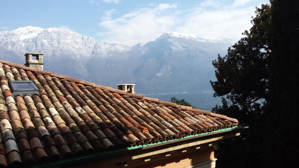 un tetto di un edificio con montagne sullo sfondo di Mansarda Ariel a Limone sul Garda