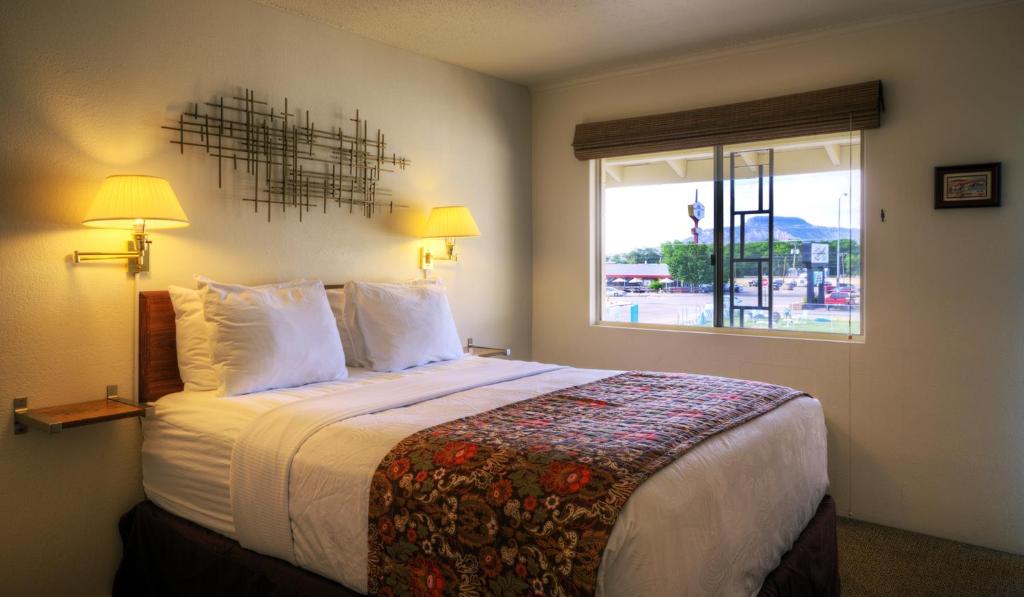 a hotel room with a large bed with a window at Roadrunner Lodge Motel in Tucumcari