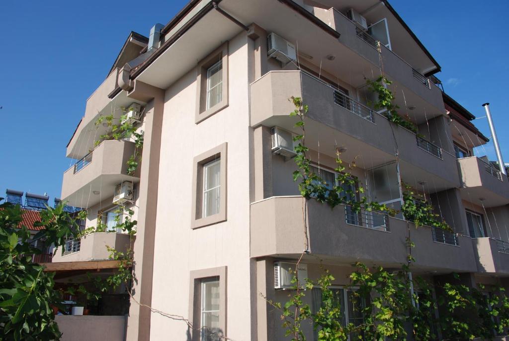 an apartment building with plants growing on it at Rodos House in Pomorie