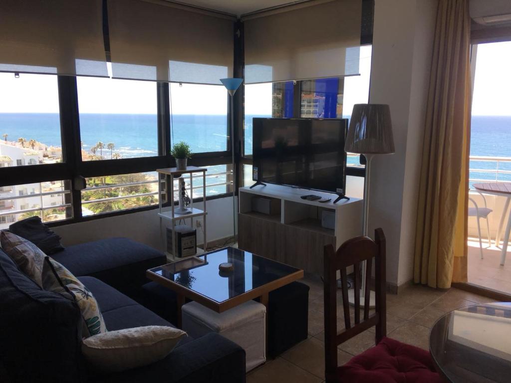 a living room with a couch and a tv and a table at Edificio Rosa de los Vientos apartamento 71 in Mijas