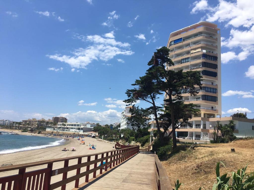 promenada wzdłuż plaży z wysokim budynkiem w obiekcie Edificio Rosa de los Vientos apartamento 71 w mieście Mijas