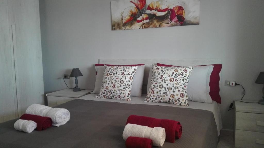 1 dormitorio con 1 cama con almohadas rojas y blancas en Casa Dolores en Baunei