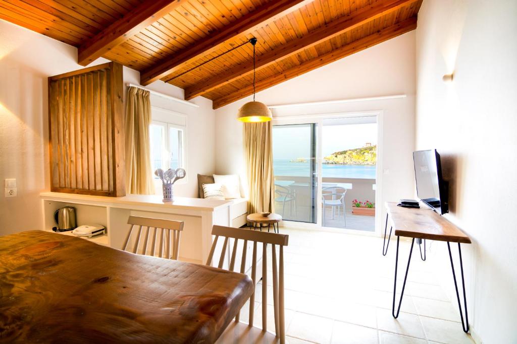 una cucina e una sala da pranzo con tavolo e vista sull'oceano di Sunrise Apartments ad Agia Pelagia