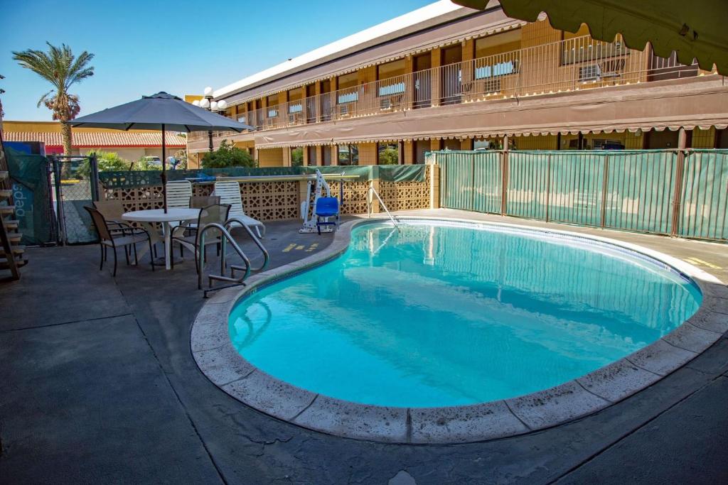 a swimming pool with a pool table and chairs at Townhouse Inn and Suites in Brawley