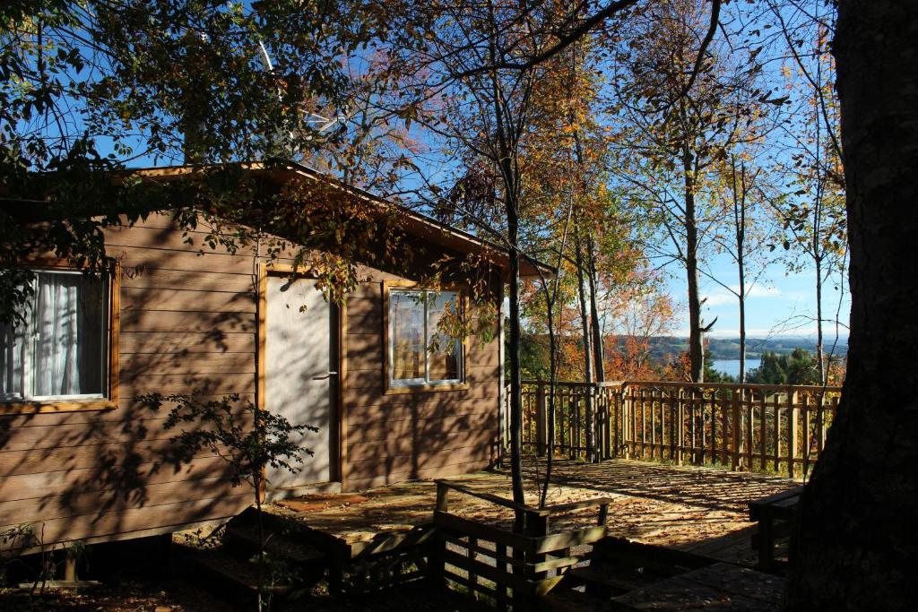een klein huis met een veranda en een hek bij Cabañas Mas Ke Miel in Lago Ranco