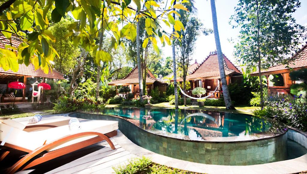 a swimming pool in front of a resort at Villa Sindu Ubud in Ubud