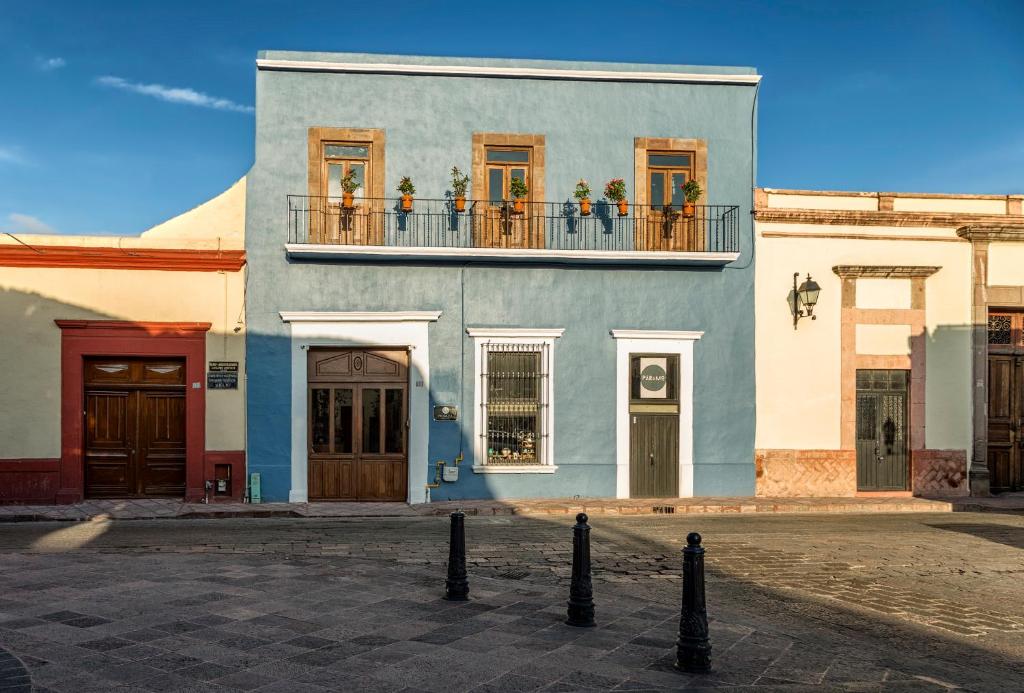 Morazul Hotel Boutique في كيريتارو: مبنى أزرق مع الزهور على الشرفة