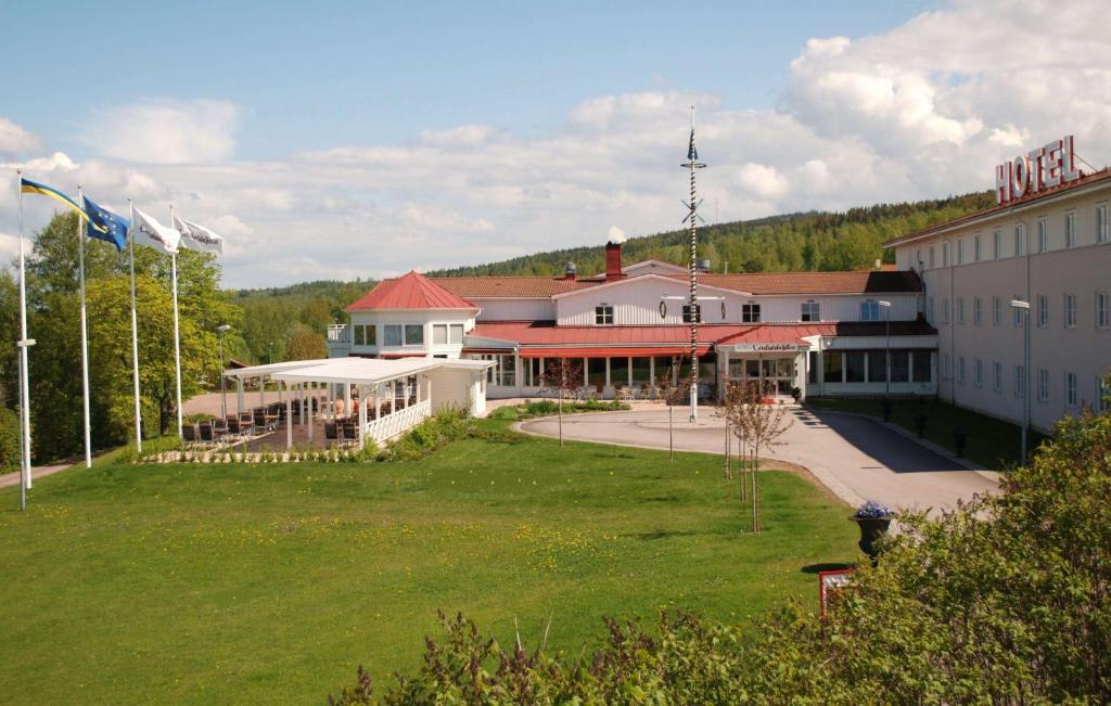 un gran edificio con un césped verde delante de él en Best Western Hotell Lerdalshoejden en Rättvik